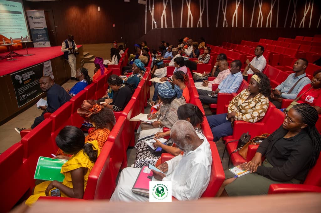 Participants taking notes from the red seats during a plenary